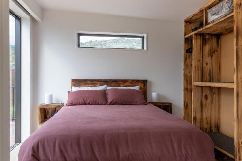 皮克顿Firkins Retreat, Picton的一间卧室设有一张大床和一个窗户。