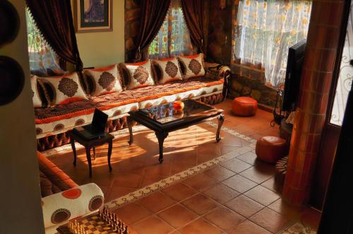 舍夫沙万Villa Authentique avec Vue Panoramique à 3 km de Chefchaouen的客厅配有沙发和桌子