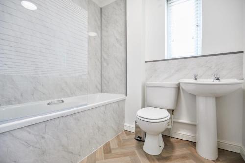 诺里奇Elegant Design 75" Smart Tv Long Stay Welcome的白色的浴室设有卫生间和水槽。