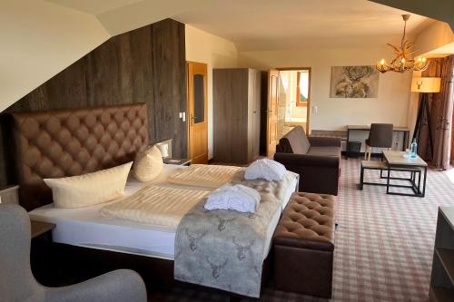巴特戈特洛伊巴Augustusberg Hotel & Restaurant的一间带大床的卧室和一间客厅