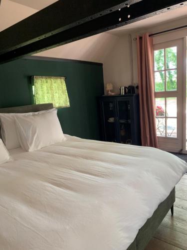 皮滕Bed and Breakfast Bakrust, met privé sauna Putten的卧室里一张大白色的床,有绿色的墙壁