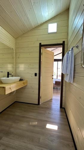 休钦斯克Гостинично-банный комплекс PARADISE的小木屋内带水槽的浴室