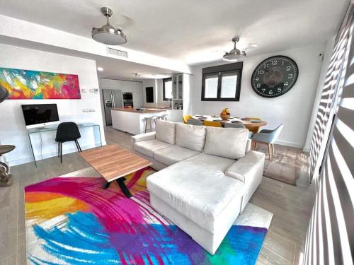 马德里Acogedora casa en Madrid con piscina privada, jacuzzy y garaje的客厅配有白色沙发和色彩缤纷的地毯。
