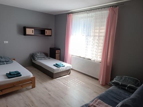 波拉伊Parkowe Ranczo的小房间设有两张床和窗户