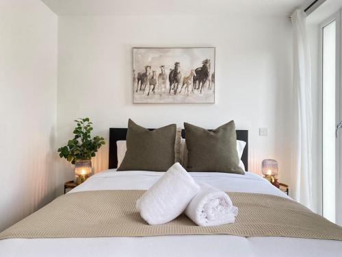 埃普瑟姆Epsom Modern Luxury 1 Bed Apartment with Extra Sofa Bed - East Street的一间卧室配有一张床,上面有两条毛巾