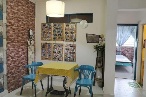 亚依淡Comfy Home Near to Penang Hill的一间设有黄色桌子和蓝色椅子的用餐室