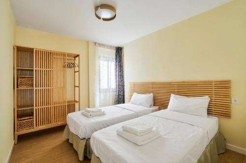 萨洛Casa Ola的一间卧室配有两张带白色床单的床