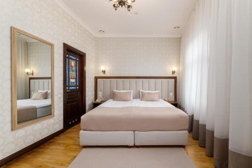 利沃夫Feder Boutique Hotel的一间卧室配有一张大床和镜子