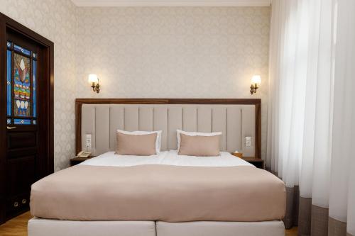 利沃夫Feder Boutique Hotel的卧室配有一张带两个枕头的大白色床