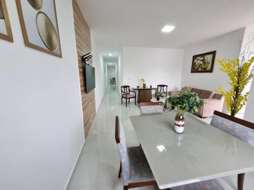 阿拉卡茹Sobrado a 200m da Praia e Orla, 02 QTS com ar condicionado的用餐室以及带桌椅的起居室。