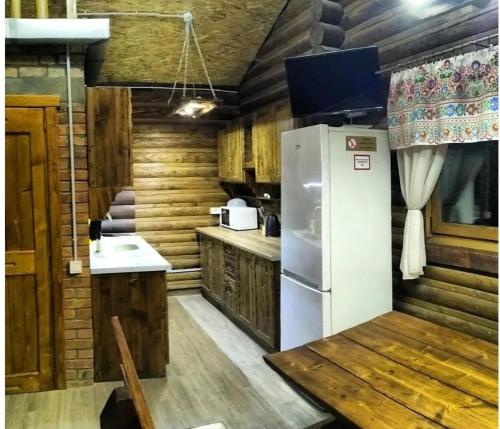 米戈韦Шаленарозі的厨房配有白色冰箱和木墙