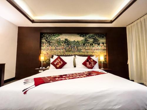万象万象城市旅馆的卧室配有带红色枕头的大型白色床
