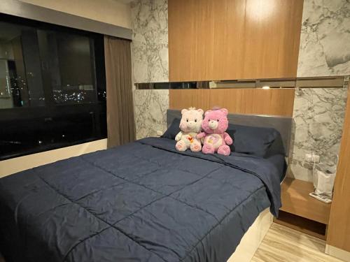是拉差Seaview condo in Siracha (Free onzen)的两只泰迪熊坐在床上
