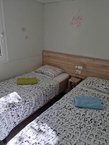 迪斯诺Mobile home Sea Jezera Village, otok Murter的小客房内的两张床,配有两张sidx sidx单人床