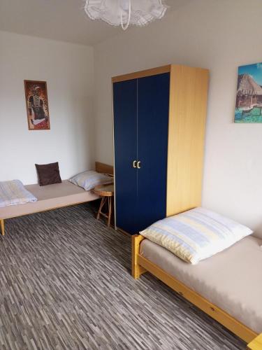伏尔塔瓦河畔赫卢博卡Ubytování u Jany的客房设有两张床和蓝色橱柜。