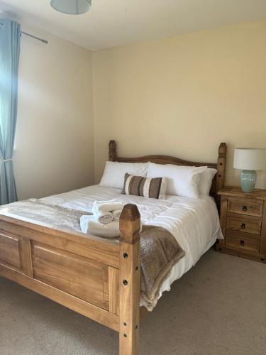 阿伯丁Stunning cozy three bedroom house near ARI的一间卧室配有一张带白色床单和枕头的木制床。