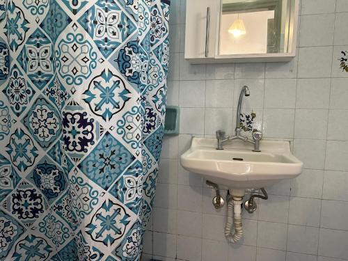 卡沃斯FULL HOUSE KAVOS的浴室设有水槽和蓝色及白色瓷砖