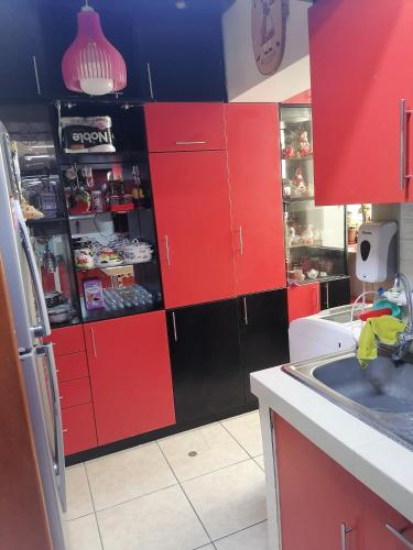 齐克拉约Residencial Las Torres de Salaverry的厨房配有红色橱柜和黑色冰箱