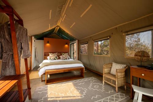 威尔吉旺登禁猎区Elephants Crossing的帐篷内的卧室,配有一张床和椅子