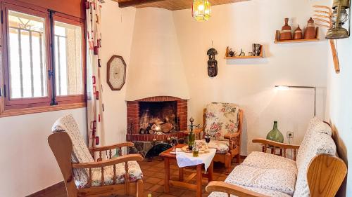 埃尔托尔诺Villa del Jerte的客厅设有壁炉、椅子和桌子