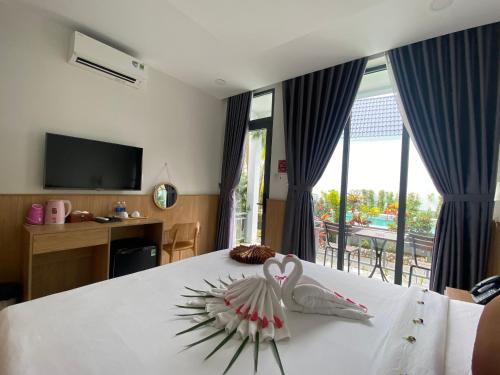 富国Ngoc Trai Xanh Bungalow的一间卧室配有一张带两个天鹅的床