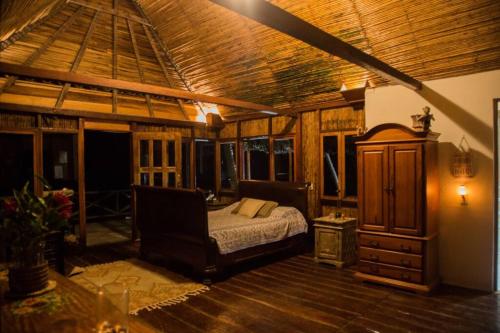 La GuayraPuntita Manzanillo, fantastic sea and jungle retreat的一间卧室设有一张床和木制天花板