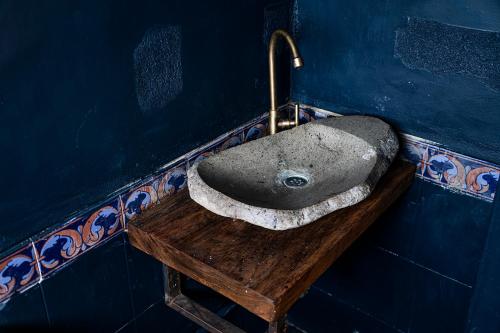 马尼萨莱斯Aldea Sabatinga的木桌上设有石制水槽的浴室