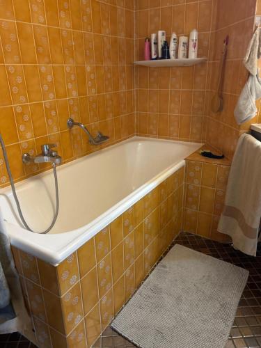 克莱恩 蒙塔纳logement entier: appartement. Chez Gilbert Crans-Montana的浴室设有浴缸,铺有橙色瓷砖。