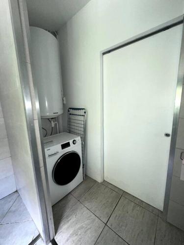 Bras-PanonAppartement 2 chambres的洗衣房配有洗衣机和门