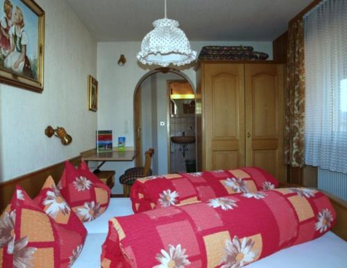内森尔旺Gästehaus Kerpf inclusive KönigsCard的一间卧室配有两张红色和白色的床