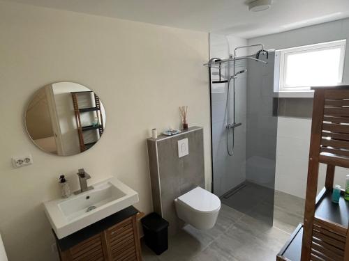 威廉斯塔德Cubana Resort Appartement loopafstand Mambo beach的一间带水槽、卫生间和镜子的浴室