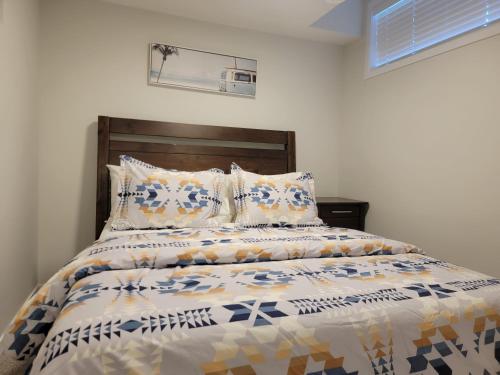 卡尔加里2-Bedroom Guest Suite的一间卧室配有一张带木制床头板和枕头的床。