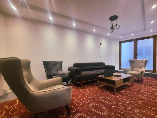 普里兹伦Comfort Hotel Prizren的客厅配有沙发、椅子和桌子
