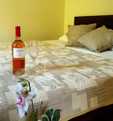 КАРИАНА хотел的床上有一瓶葡萄酒和一杯玻璃及鲜花