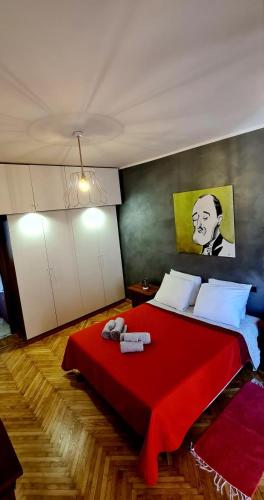 都灵Ottimo appartamento " Pala Alpitour"的卧室配有红色的床,墙上挂有绘画作品