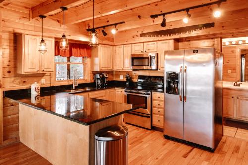 赛维尔维尔Expansive Mountain Views, Theater, Games, Hot Tub, Relaxing porches的厨房配有木制橱柜和不锈钢冰箱。