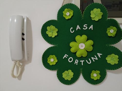 塔兰托CASA VACANZE : CASA FORTUNA的手机旁的绿色四叶布叶标志