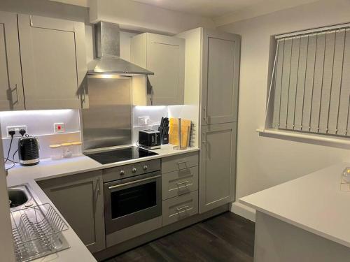 南安普敦Newly Refurbished Apartment with private parking的一间带炉灶的厨房 水槽旁的顶部烤箱
