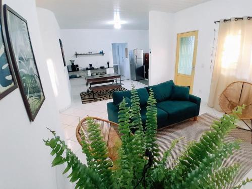 戈亚斯州上帕莱索Casa central aconchegante的客厅配有绿色沙发和植物