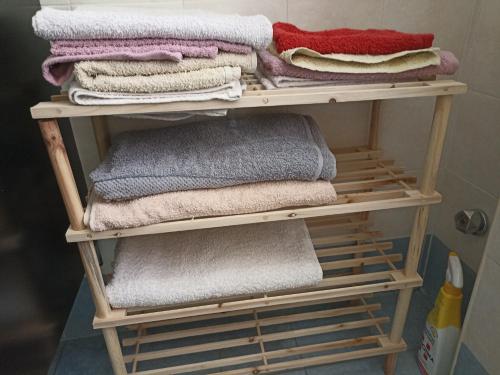塔兰托CASA VACANZE : CASA FORTUNA的浴室的木架上堆着毛巾