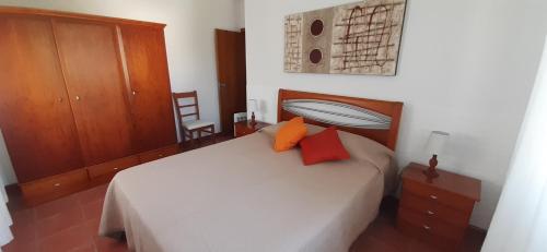 RibeirinhaCasinha do Chorão的卧室配有白色床和2个橙色枕头