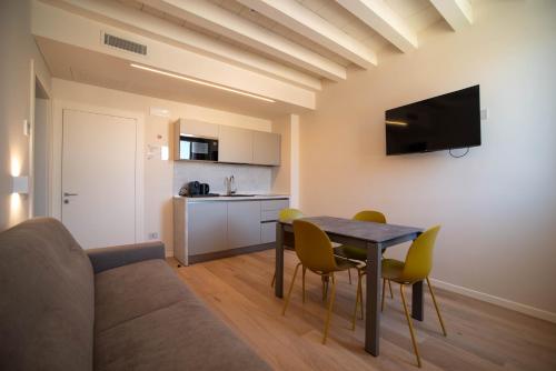 维罗纳Calcirelli Suites的一间带桌椅的客厅和一间厨房