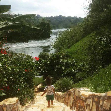 金贾Nileit Campsite Jinja的一条小女孩沿着河边的小径走