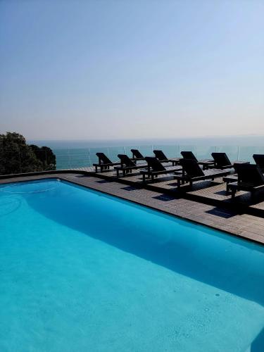 戈登湾Bikini Beach Manor的一个带椅子的游泳池,享有海景