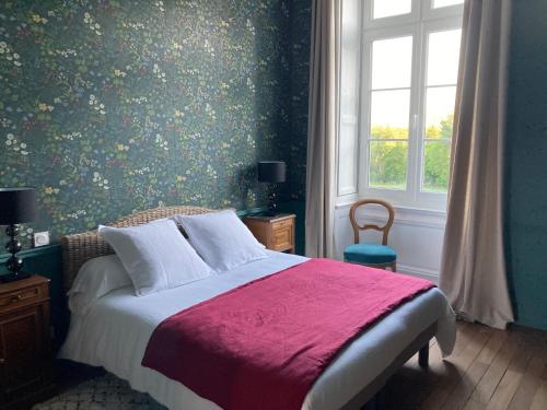 奥尔沃Le Plessis的一间卧室配有一张带红色毯子的床和窗户。