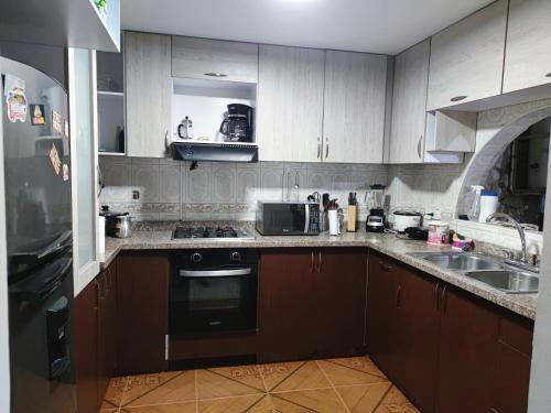 卡利Hospedaje Casa Aurora的厨房配有水槽和炉灶 顶部烤箱