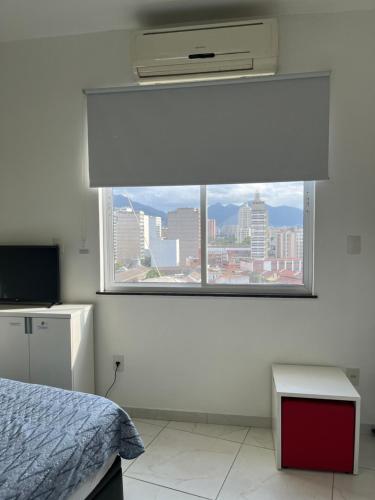 里约热内卢菲奥拉凡公寓的一间卧室设有窗户,享有城市美景