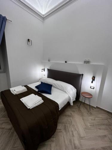 那不勒斯Dimora Dei Decumani的一间卧室配有一张大床和毛巾