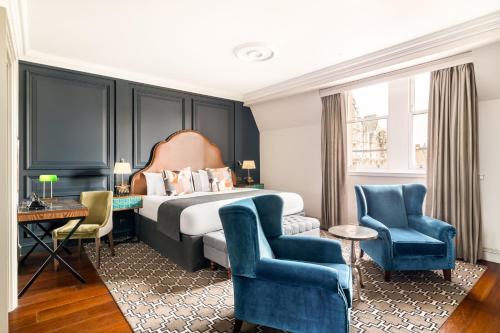 爱丁堡英国皇家王子街酒店的酒店客房,配有一张床和两张蓝色椅子