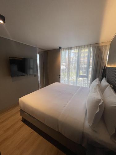 圣地亚哥One Manquehue Aparthotel的卧室配有一张大白色床和窗户